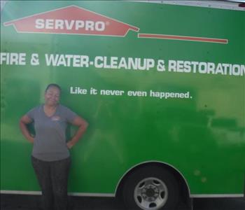 female employee standing in front of a SERVPRO green truck.