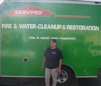 female employee standing in front of a SERVPRO green truck.